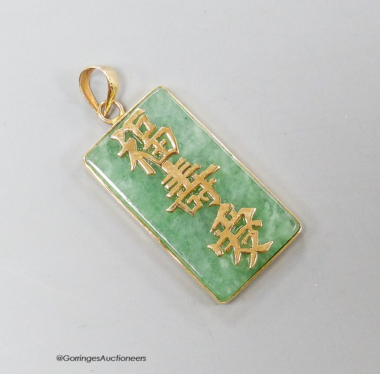 A Chinese yellow metal mounted jadeite rectangular pendant, with Chinese characters, 25mm, gross 4.7 grams.